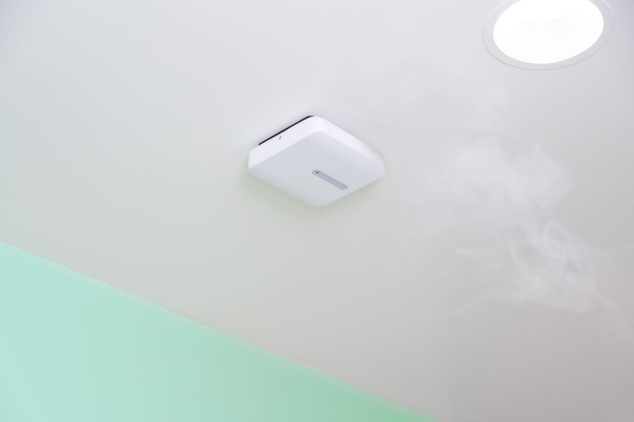 Verkada air quality sensor mounted on white ceiling with visible smoke or vapor nearby.