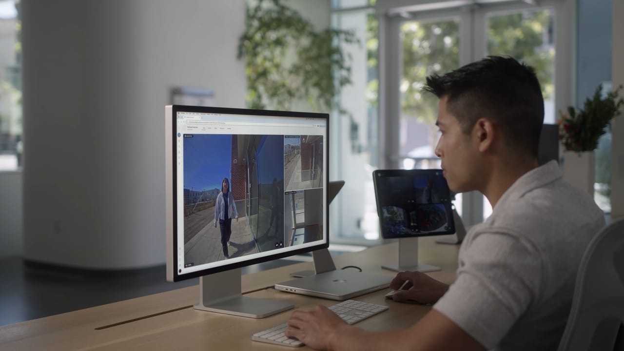 Security operator monitors Verkada intercom camera feeds on a desktop computer at a reception desk.