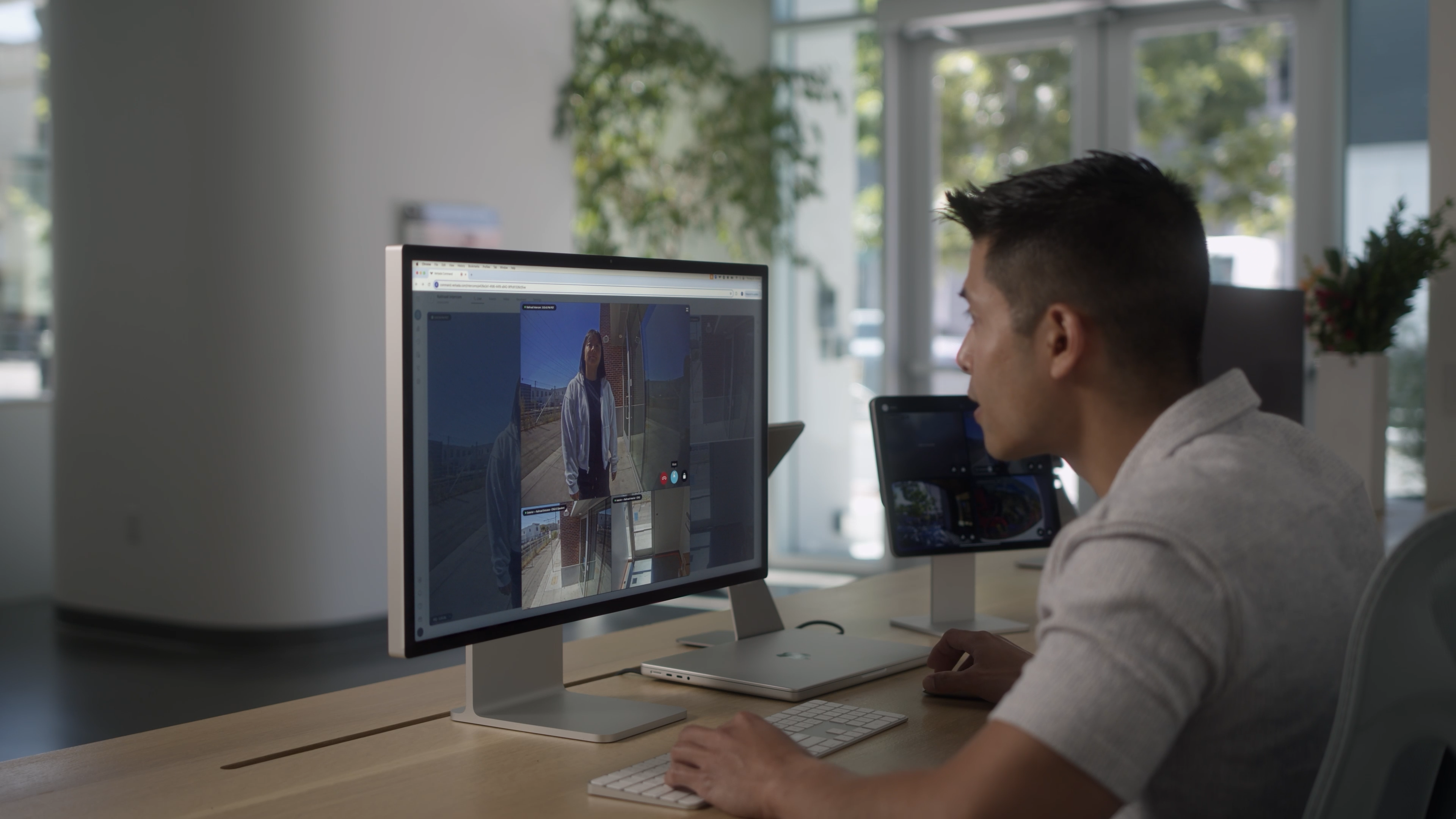 A man at a desk views a Verkada intercom live call on a large monitor.